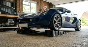 Black, low-profile car ramps positioned in a modern British garage, designed specifically for sports cars and lowered vehicles with minimal ground clearance.