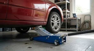 A low-profile trolley jack positioned under the chassis of a lowered British hatchback to demonstrate clearance.