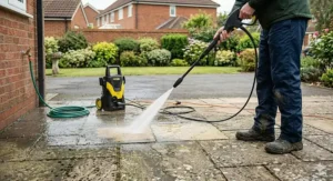 A photorealistic safety guide for using the best pressure washer, displaying essential gear including waterproof boots, goggles, a face mask, and protective gloves on a workshop bench.