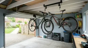 A narrow residential hallway and garage entry showing how a ceiling bike rack lifts an electric bike completely clear of pedestrian walkways.