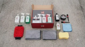 Overhead flat-lay showing all contents included in a budget car valeting kit under £50, ready for driveway use.