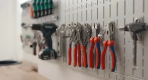 Traditional J-hook pegboard mounting style being used to hang garden shears and hand tools.
