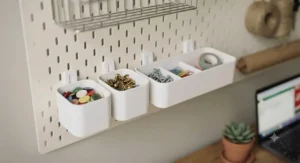 Plastic storage bins attached to a pegboard for small bits and bobs organisation.