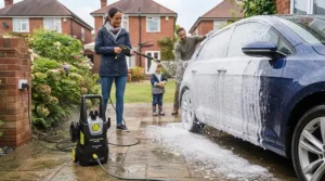 Foam cannon attachment on an affordable electric pressure washer under £150 being used to wash a family hatchback outside a British home.