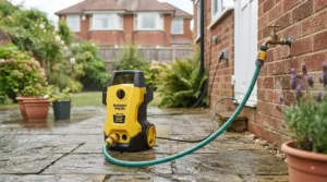 A homeowner easily carrying a lightweight, compact pressure washer designed for small British gardens and sheds.