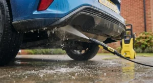 Using an underbody lance to wash away winter salt from a car chassis.