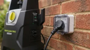 Close-up of the integrated safety auto-stop switch and standard UK 3-pin plug on an electric pressure washer under £150.