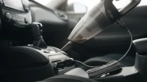 12V plug-in portable car vacuum connected to a car auxiliary power socket for continuous power.