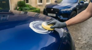 A bottle of all-in-one polish and wax next to a gleaming car bonnet, showcasing a brilliant finish on British roads.