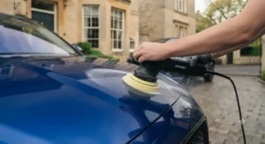 Using all-in-one polish and wax to restore shine to dull exterior chrome trim on a car.