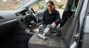 Compact cordless car vacuum cleaner tackling stubborn pet hair on fabric upholstery