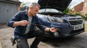 An experienced driver checking engine oil for high mileage cars before a long journey on the M1